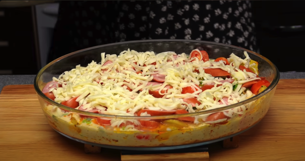 Gălătul de cartofi cu amestec de ouă, legume, smântână acră, cârnați și brânză